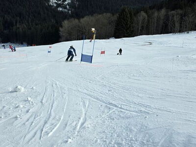 Ein Schüler fährt den Schneehang auf Skiern hinab