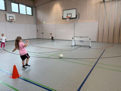 Ein Schülerin schießt einen Ball auf ein Tor