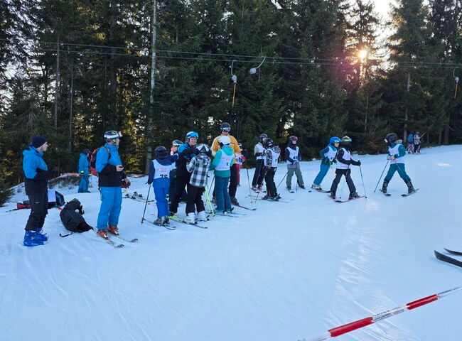 Eine Gruppe Schüler steht auf Skiern im Schnee
