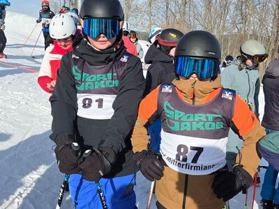 Zwei Schüler auf Skiern mit Startnummern