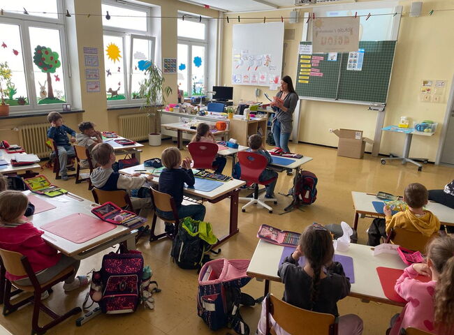 Frau Riedl steht vor der Klasse mit einem Gebissmodel