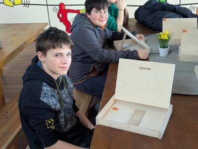 Schüler haben einen selbstgebauten iPad‑Halter aus Holz vor sich