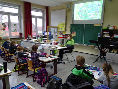 Klasse 2a: Büchereileiterin Sabine Rengsberger erfreut die Kinder mit einer Geschichte aus dem Buch: Der Happaflapp reist in den Müthenwald von Michael Engler
