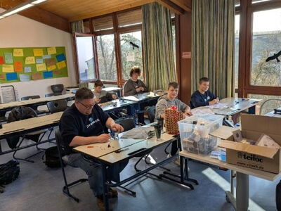 Schüler und Ausbilder sitzen an Tischen