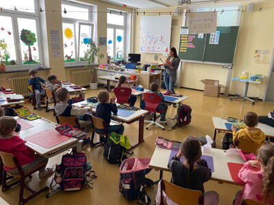 Frau Riedl steht vor der Klasse mit einem Gebissmodel